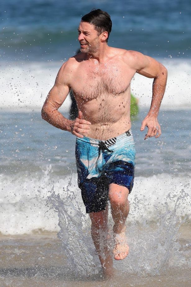 【写真を見る】50代にして圧巻のたくましい身体！ビーチを走るヒュー・ジャックマン