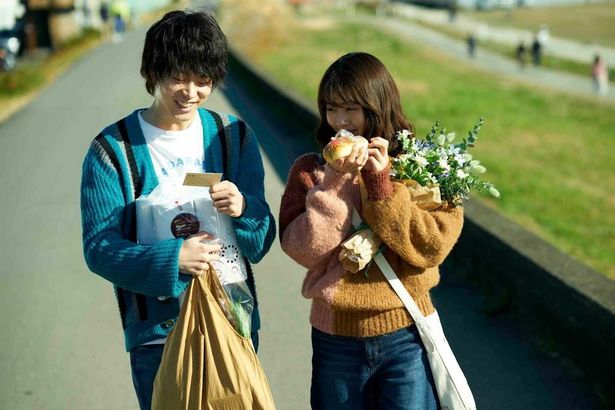 花束を持ちながら仲良く散歩する2人