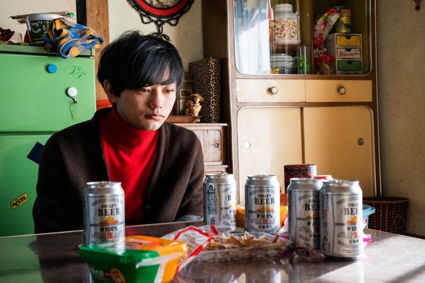 ビールの空き缶を前に虚ろな表情の20代のマサルを演じる渡辺佑太朗