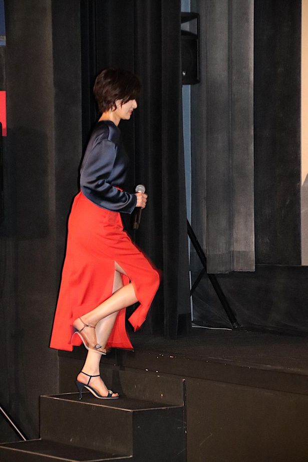 【写真を見る】吉瀬美智子、スリットの入った鮮やかカラーのスカートで登場