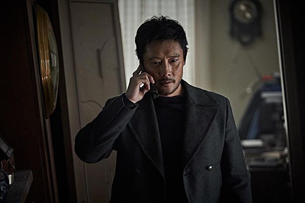 電話を片手に深刻な表情を浮かべるイ・ビョンホン演じる工作員リ・ジュンピョン