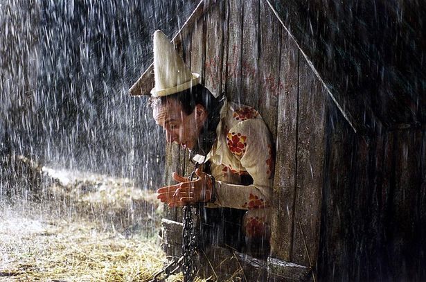 雨の中、鎖につながれているピノッキオ(『ピノッキオ』)