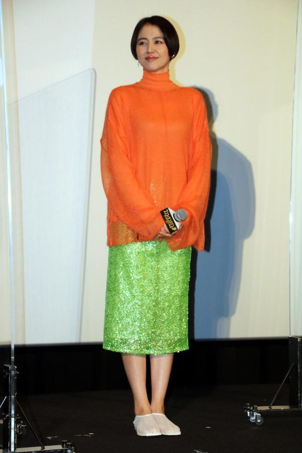 【写真を見る】長澤まさみは、オレンジのトップ×ラメのグリーンスカートでコーディネート