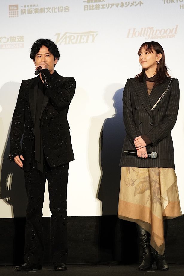 【写真を見る】稲垣吾郎は、キラキラと輝くブラックスーツ。新垣結衣はアシンメトリーのスカーフ柄スカートで登場