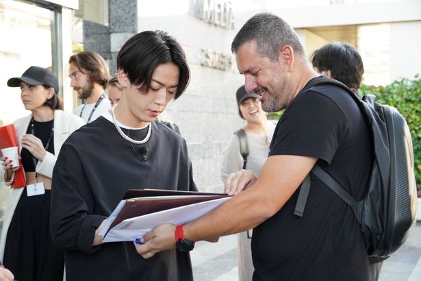 【写真を見る】シッチェスで現地のファンに囲まれる亀梨和也。写真撮影やサインを求める声にも真摯に応えた