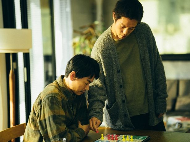 吉井と先輩の村岡がボードゲームをしている緊迫感あるカット