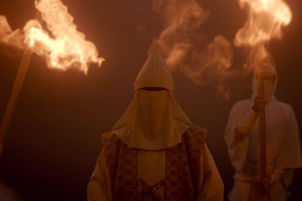 顔までを白い衣装で覆った人物たちによる怪しい儀式の様子(「七夕の国」第2話場面写真)