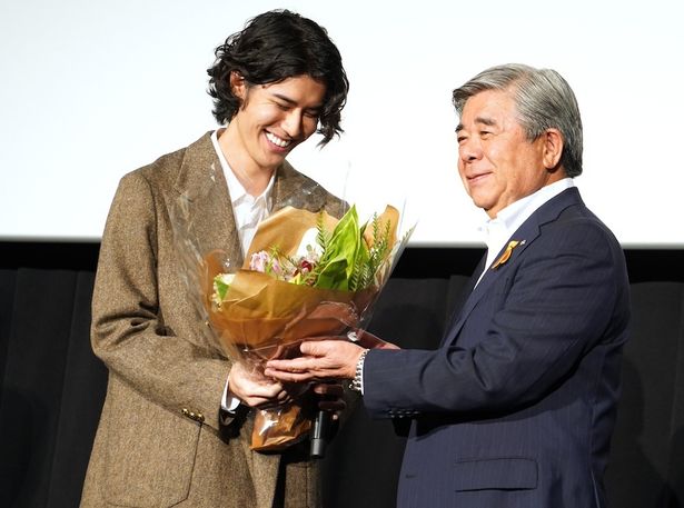 【写真を見る】ロケ地となった北海道・白糠町長が花束を持って登場！うれしそうに花束を見つめる寛一郎