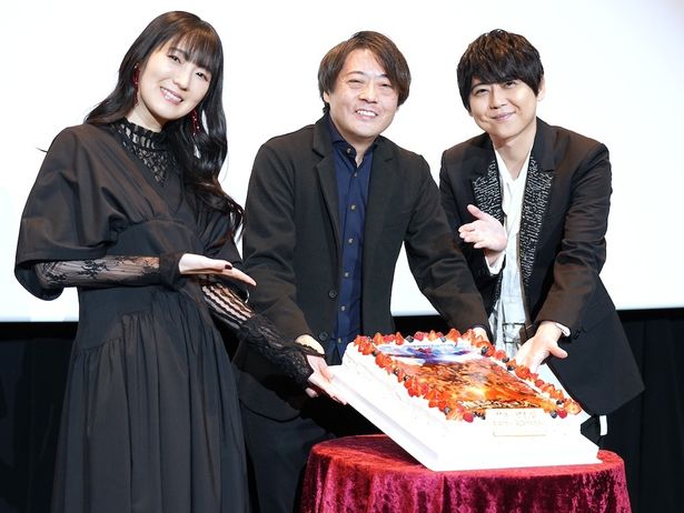 【写真を見る】11月9日が誕生日の林祐一郎監督は、梶裕貴、石川由依、バースデーケーキと一緒に記念写真でニッコリ