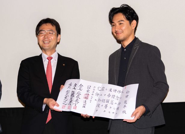 【写真を見る】羽生善治竜王の署名も入った免状を贈呈され、満面の笑顔を見せる松田初段