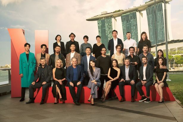 【写真を見る】イベントに集まったキャストとクリエイターたちが、シンガポールのランドマーク、マリーナ・ベイ・サンズをバックに記念撮影