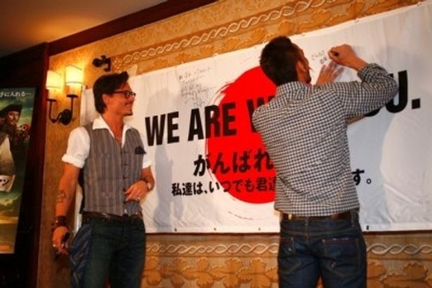 【写真】横断幕に日本のファンへメッセージを書き込むジョニー・デップと中田英寿