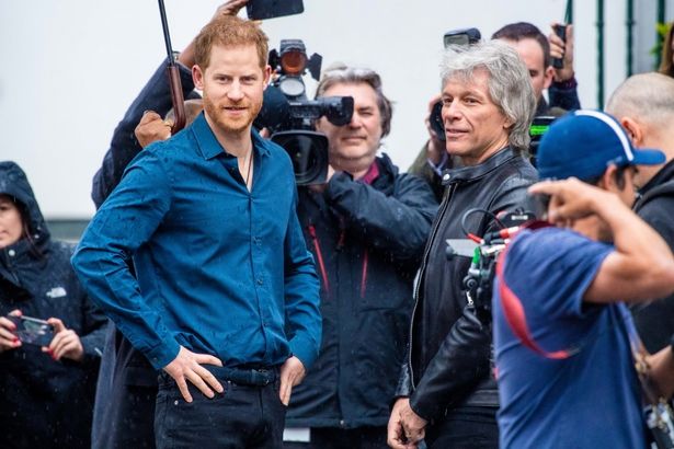 【写真を見る】ヘンリー王子、ジョン・ボン・ジョヴィと対面で感激！衣装チョイスは雨のロンドンに不正解？