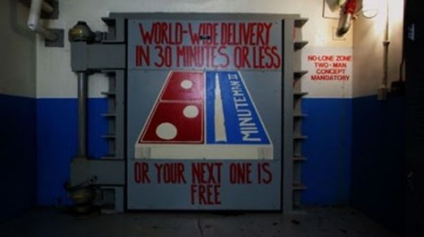 “世界各地に30分でお届け！届かなければ無料でもう一つ…”とのイラストが書かれた核弾頭ミサイル発射基地の扉