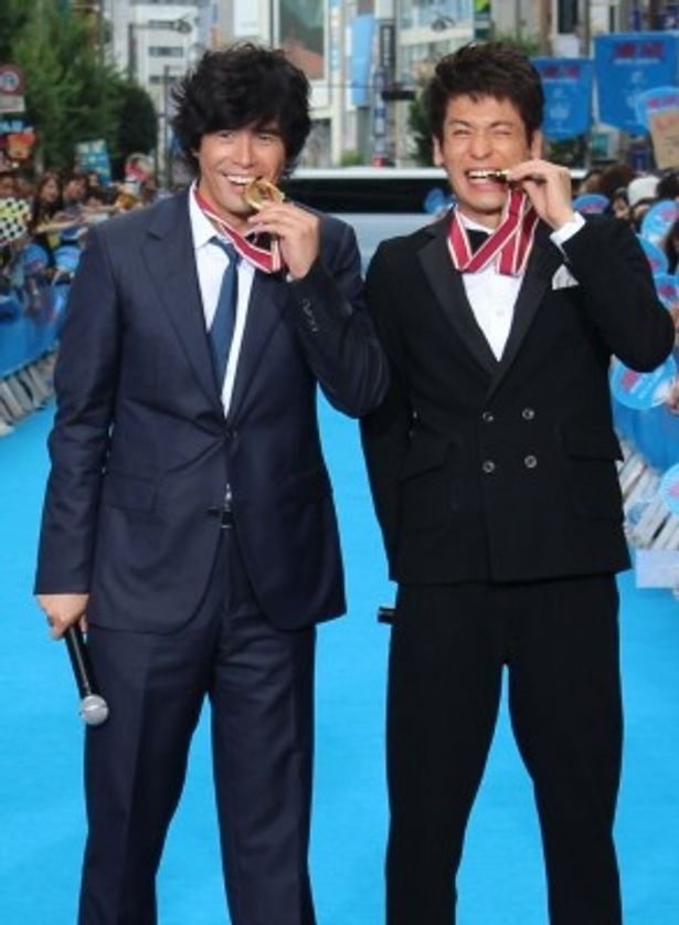 【写真を見る】ファンを前に満面の笑顔！金メダルをかじってみせた伊藤英明と佐藤隆太