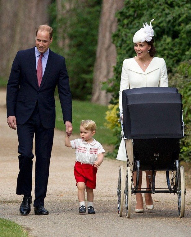 【写真を見る】ウィリアム王子と手をつなぎ、乳母車を押すキャサリン妃と並んで歩くジョージ王子。まるで女の子のよう