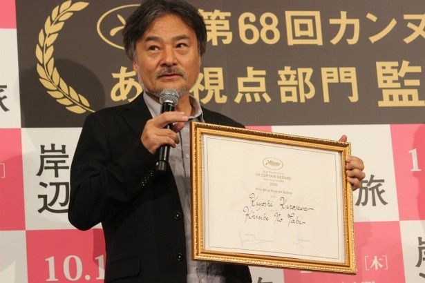 カンヌ映画祭の監督賞の賞状を手にした黒沢清監督