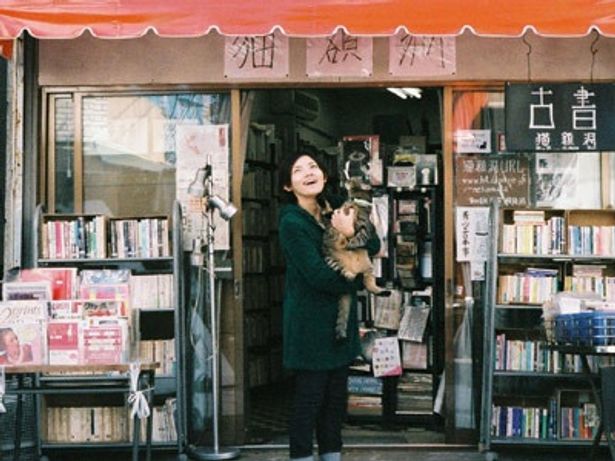 下町の雰囲気溢れる古本屋。その店先にて猫を抱きかかえる星野