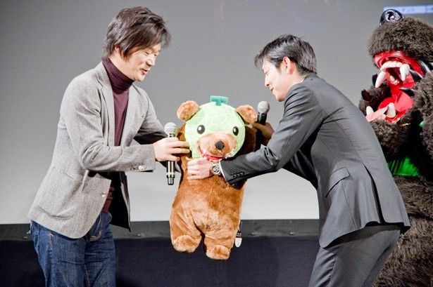 【写真を見る】鈴木市長からかわいい夕張メロン熊のぬいぐるみをプレゼントされるジェシー代表